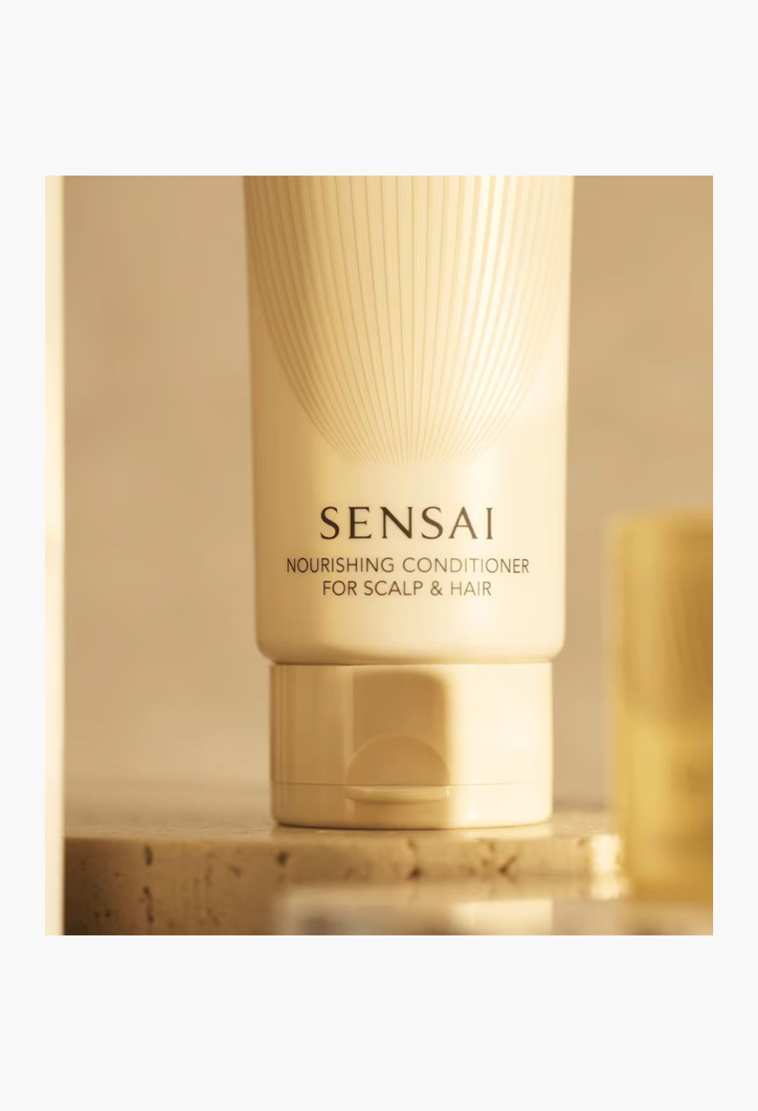 GLAM MODA SENSAI Nourishing Conditioner in a sleek beige tube for scalp and hair care on a textured surface.