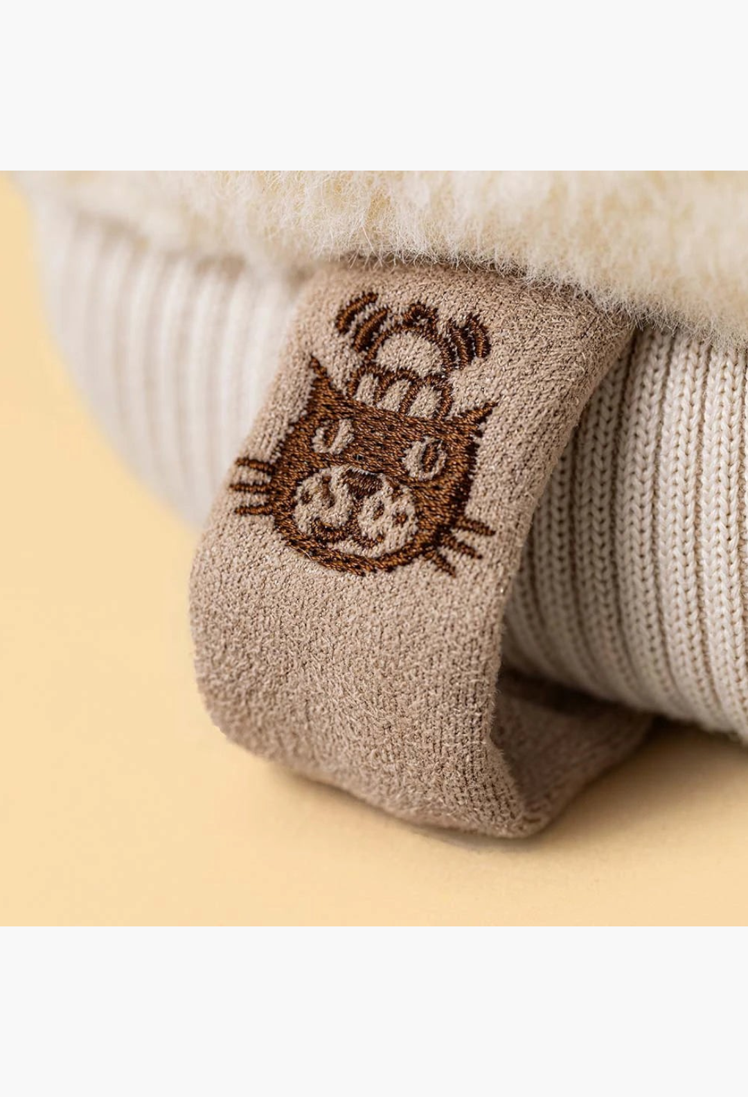 GLAM MODA Amuseables Fitswell Mitten plush toy featuring a soft cream textured fabric and a brown embroidered tag