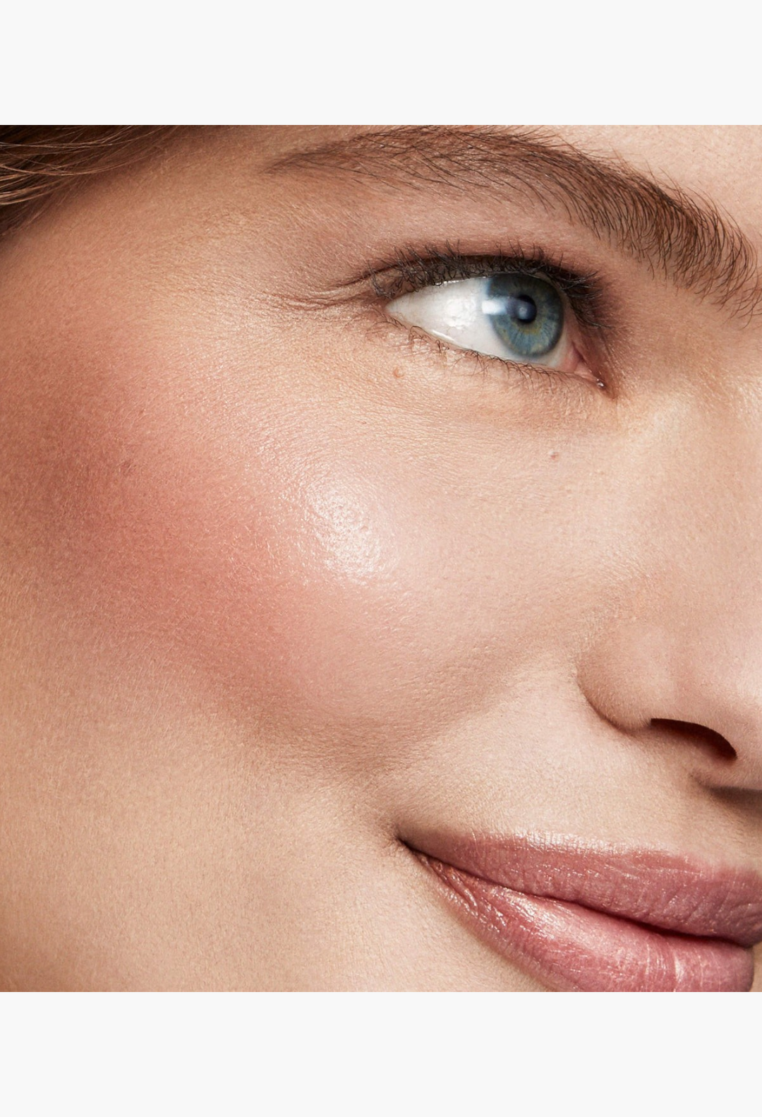 GLAM MODA Baby Cheeks Blush Stick applied to a model's cheek for a natural, flushed-from-within pink glow.