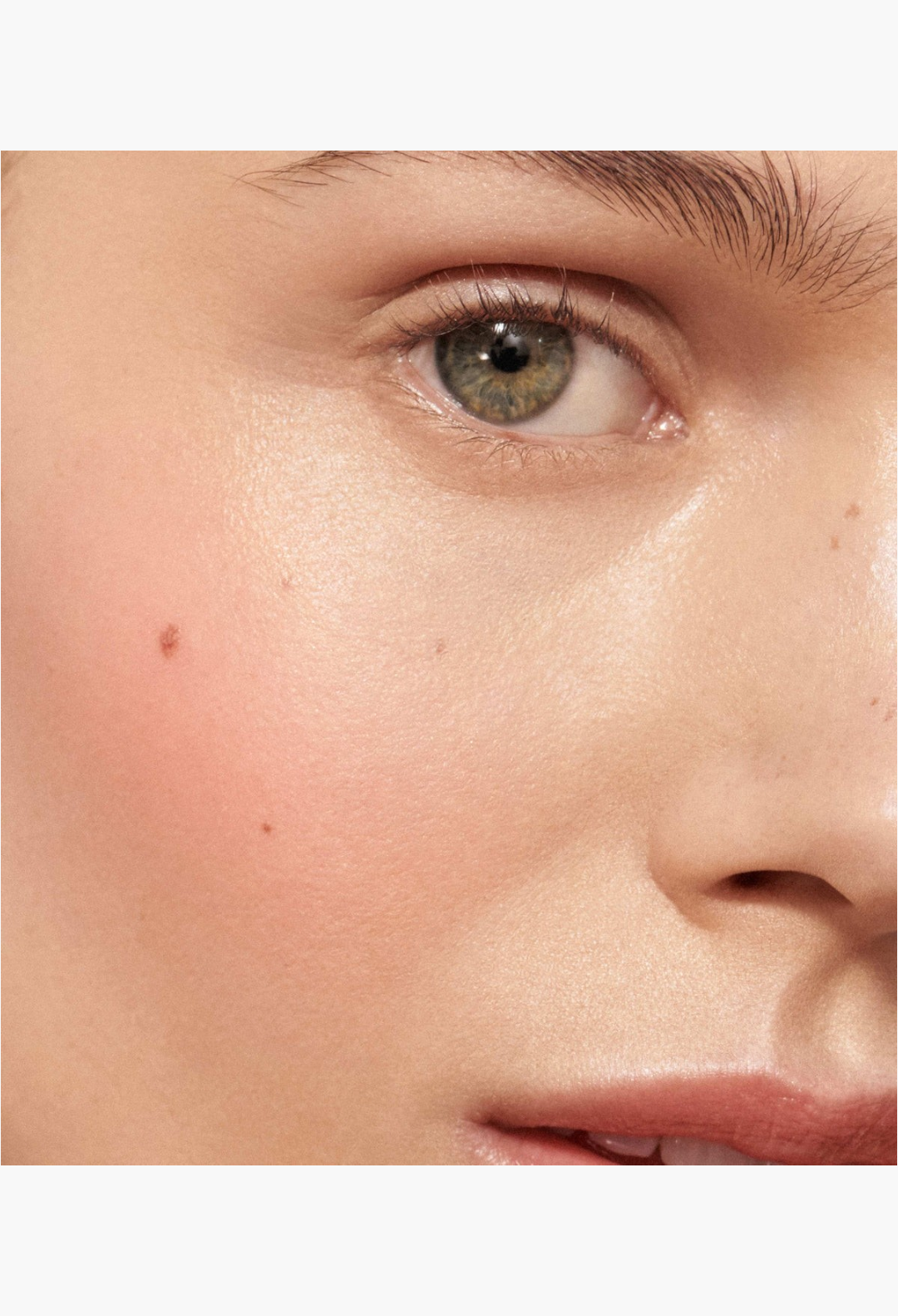 GLAM MODA Baby Cheeks Blush Stick applied to a model's cheek for a natural, flushed-from-within pop of color.