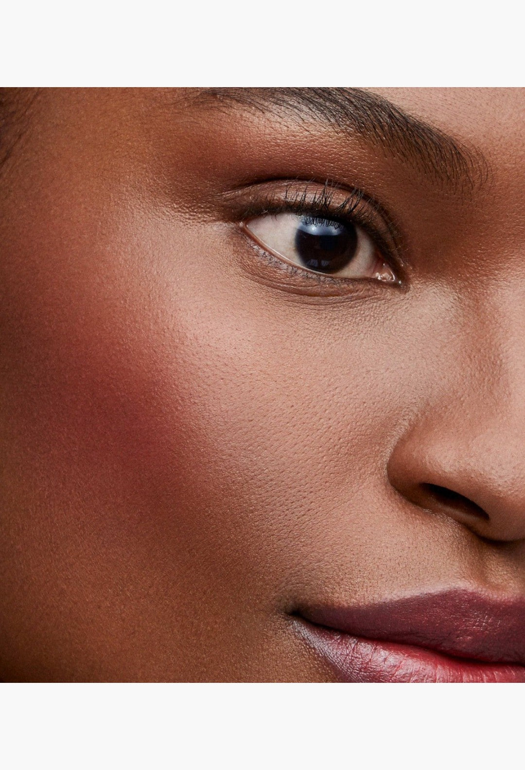GLAM MODA Baby Cheeks Blush Stick applied to a model's cheek for a natural, flushed-from-within pop of color
