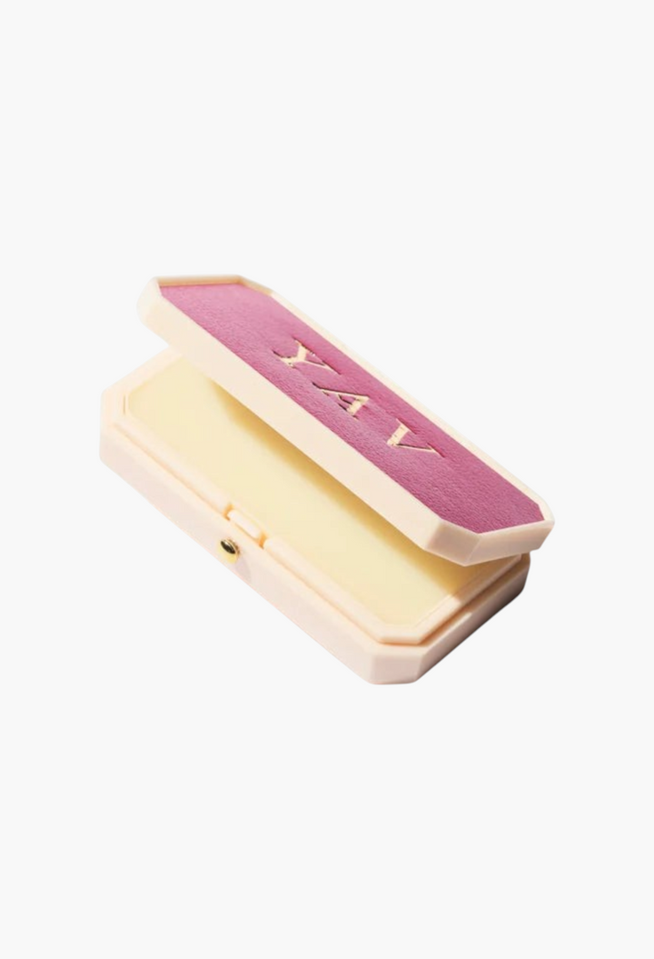 GLAM MODA Baume des Muses lip balm in an ivory case with a pink lid featuring embossed gilt lettering