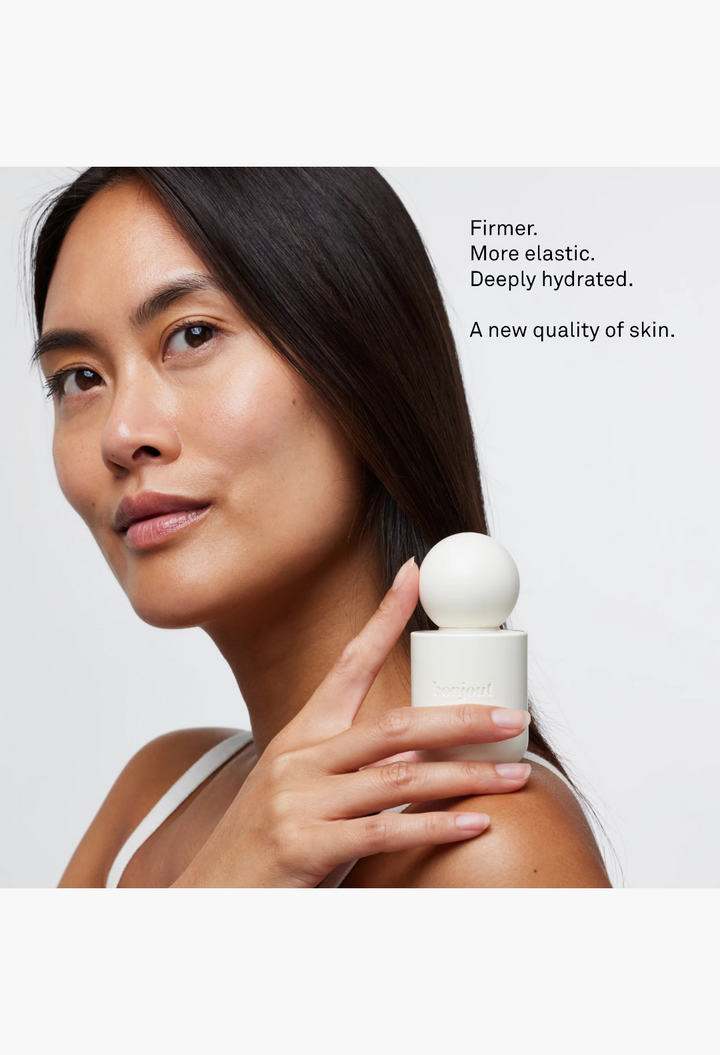GLAM MODA La Cream Skin Longevity Crème in a minimalist white bottle held by a woman with radiant, hydrated skin.