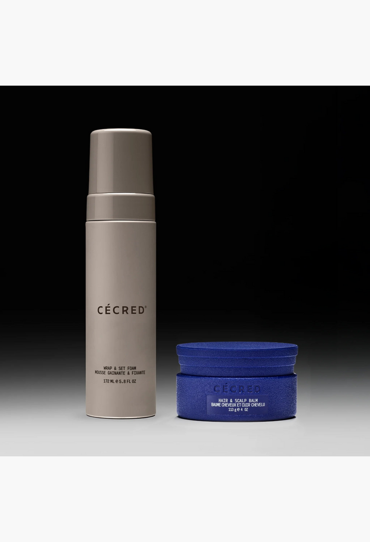 GLAM MODA Braid-Out Bundle featuring a beige Wrap & Set Foam bottle and a blue Hair & Scalp Balm jar on black background