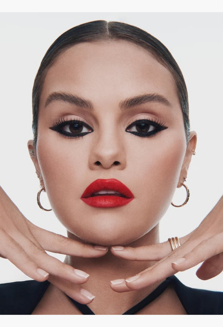 GLAM MODA Kind Words Matte Lip Liner in a bold red shade applied on a model with winged eyeliner and gold hoops.
