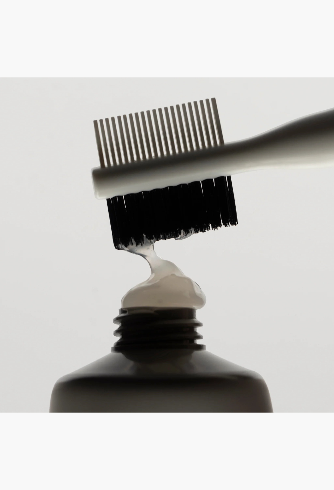GLAM MODA Strong Hold Gel being applied with a styling brush, showing the clear, non-flaking texture of the hair product.