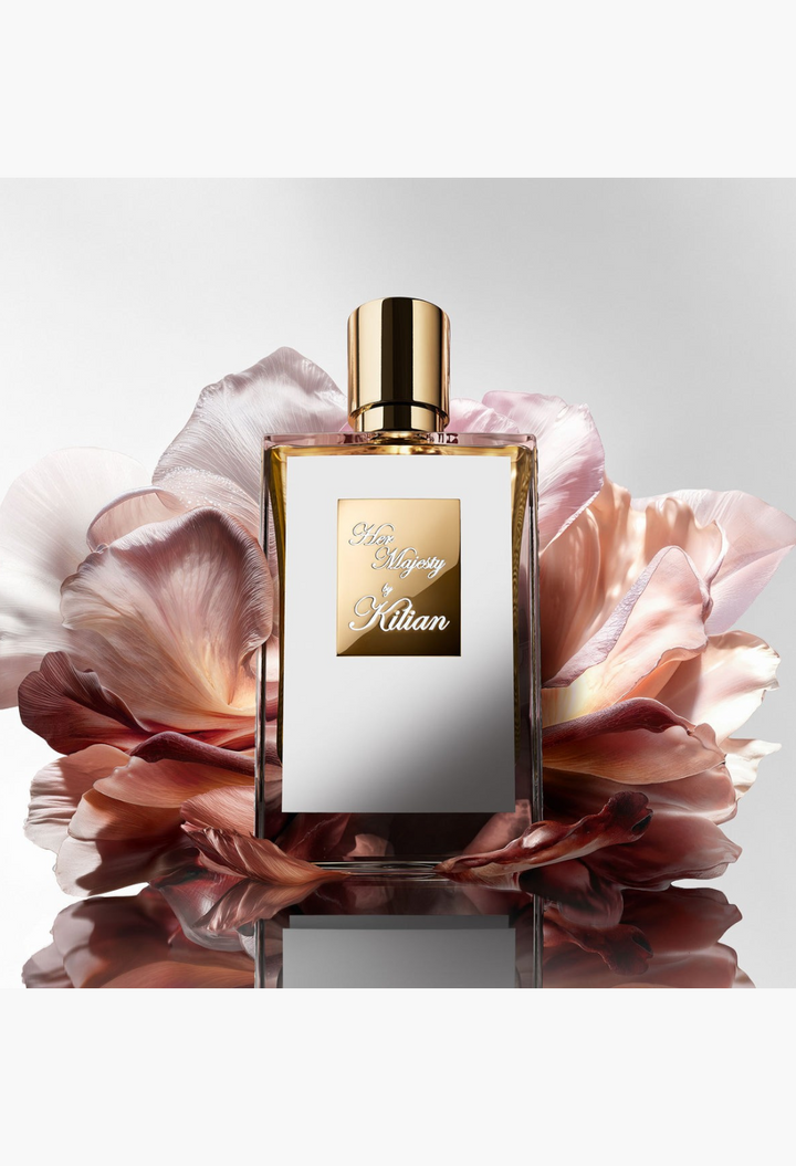GLAM MODA Her Majesty Eau de Parfum bottle with gold cap, centered against soft, layered pink and white flower petals.