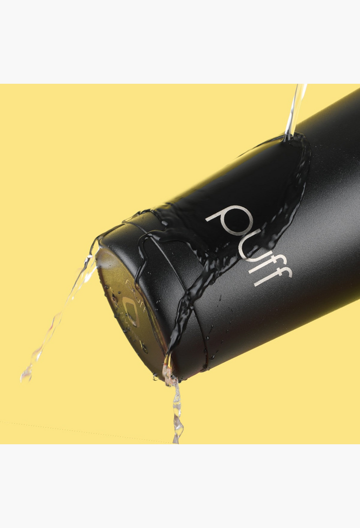 GLAM MODA Matte Shaker stainless steel water bottle in black with water splashing against a yellow background