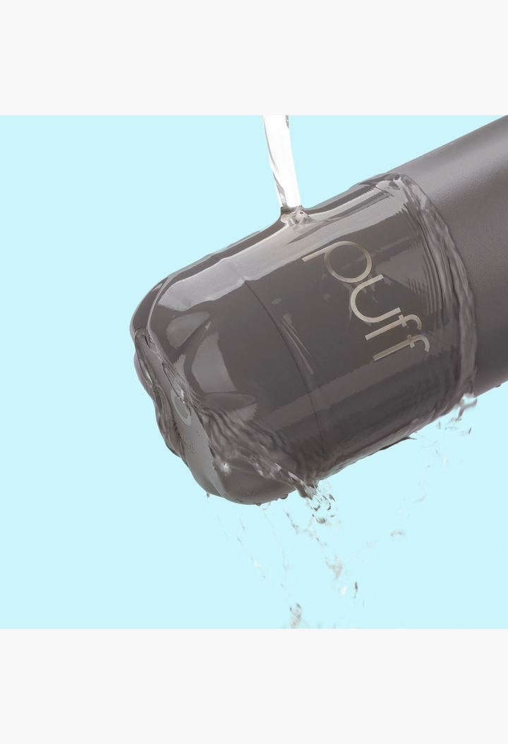 GLAM MODA Matte Volcanic Puff stainless steel insulated water bottle being rinsed with water against a blue background