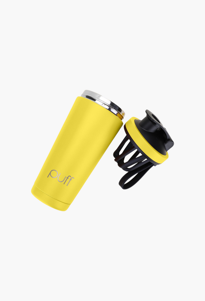 GLAM MODA yellow Puff Shaker stainless steel insulated bottle with black lid and mixing whisk on purple background