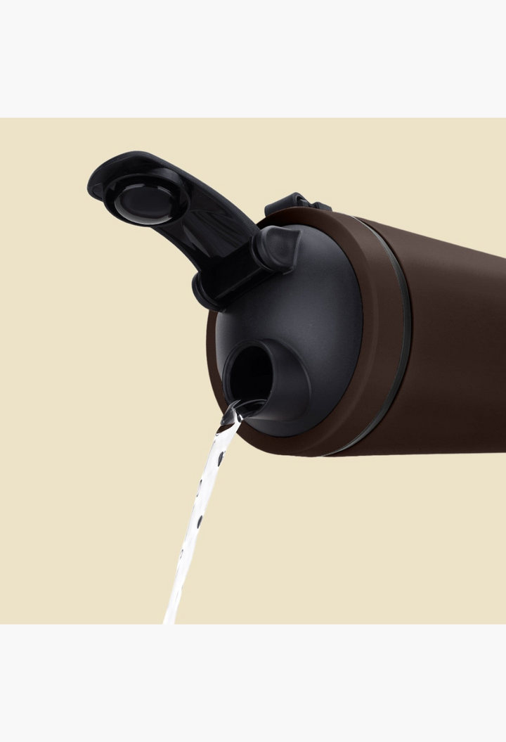 GLAM MODA matte brown stainless steel shaker bottle with a black flip-top lid pouring water