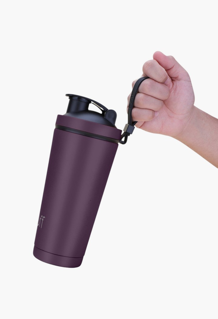 GLAM MODA matte dark purple stainless steel insulated shaker bottle with a black carry strap held by a hand
