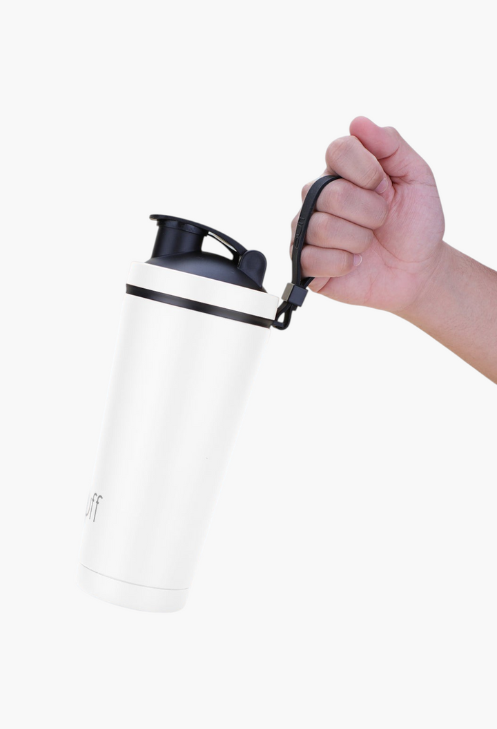 GLAM MODA white stainless steel insulated shaker bottle with a black lid and carrying strap held by a hand