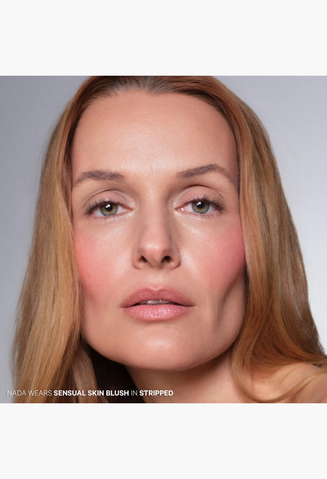 Model wearing GLAM MODA Sensual Skin Blush in Stripped, a light berry cream-to-powder formula for a soft-focus finish.