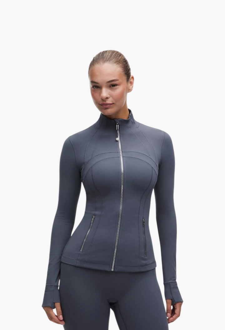 GLAM MODA Define Jacket Nulu in dark grey, featuring a slim fit, zippered pockets, and thumbholes in soft fabric.