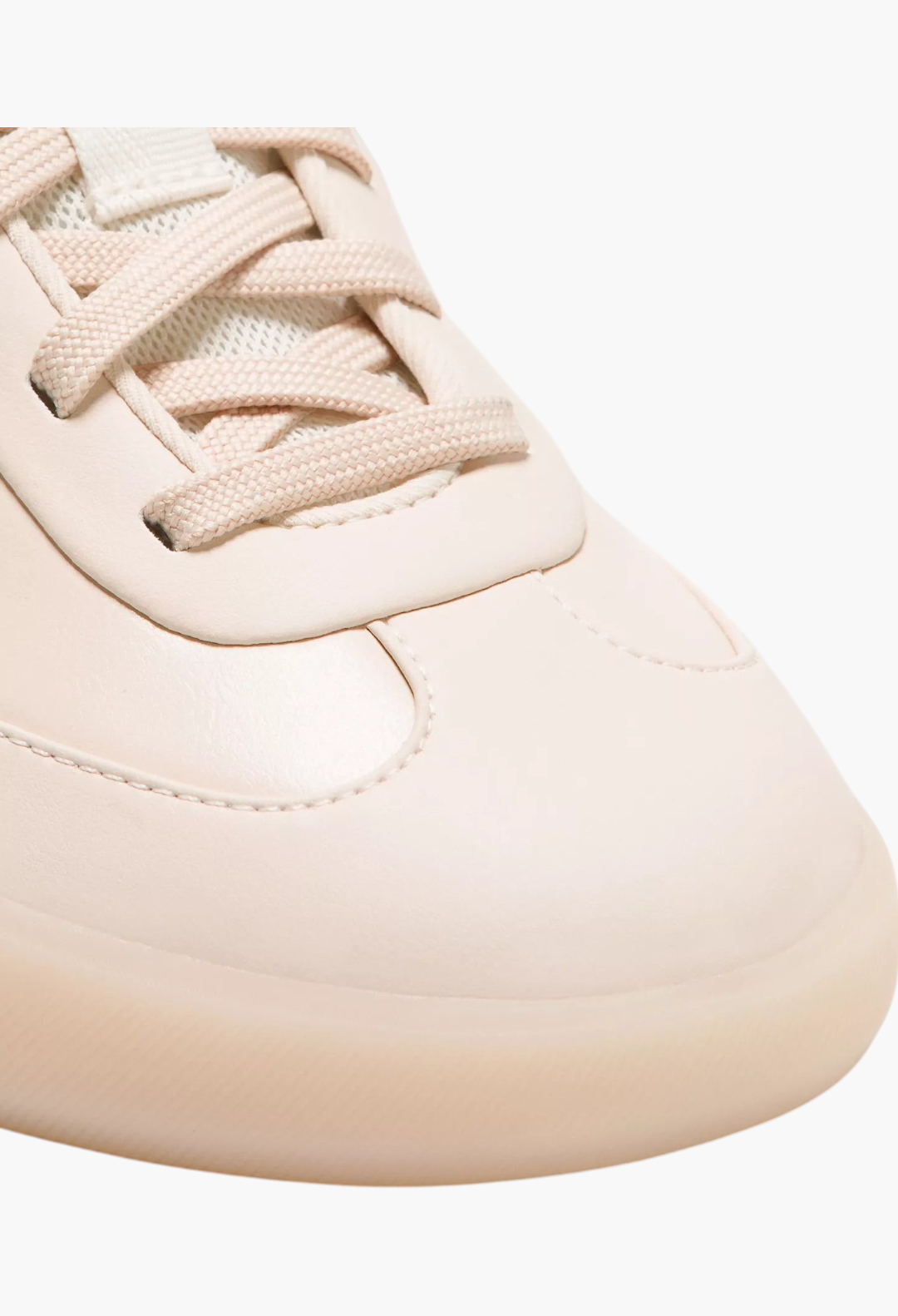 Close-up of GLAM MODA Cityverse sneaker in cream with leather-alternative upper, exposed stitching, and rubber sole.