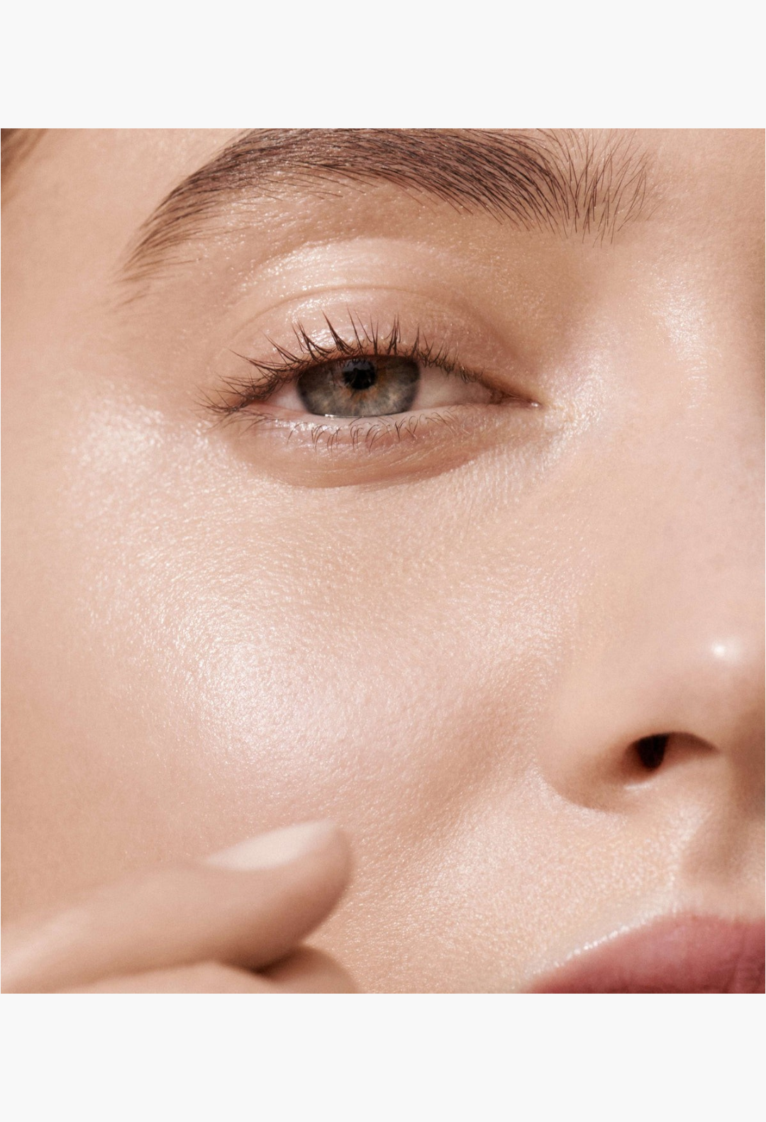 GLAM MODA Lit Up Highlight Stick applied to a model's cheekbone for a radiant, glassy, and hydrated skin finish.