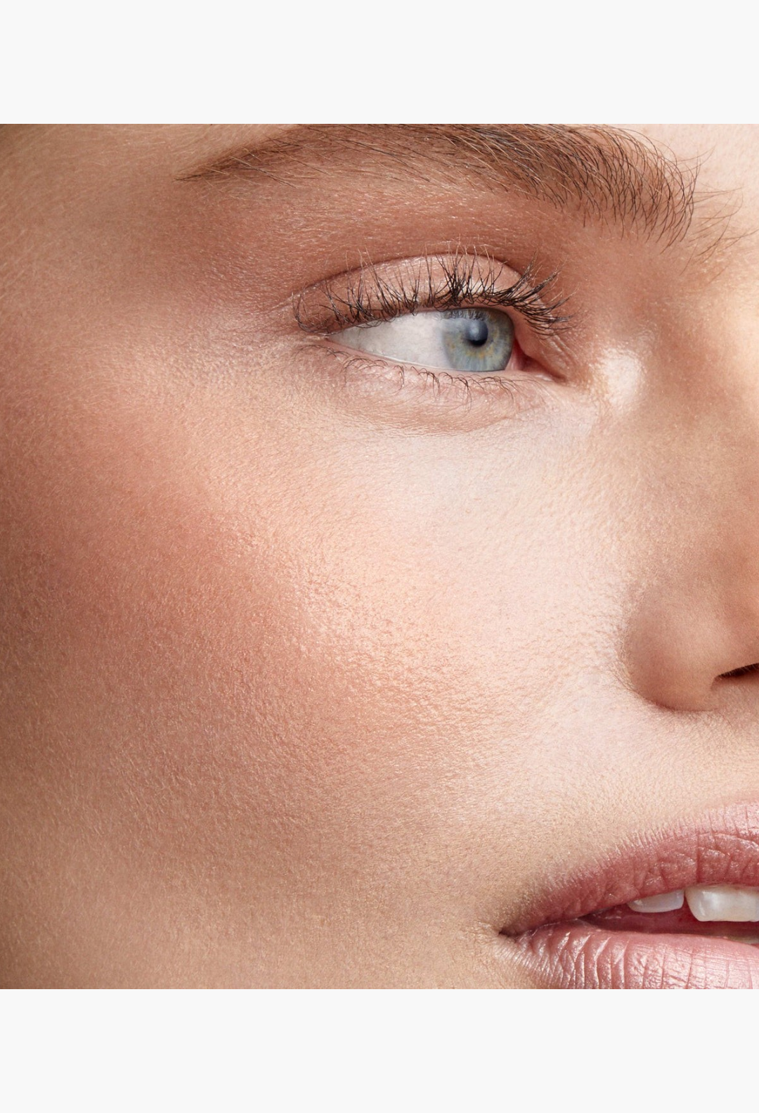 GLAM MODA Lit Up Highlight Stick applied to cheekbone for a radiant glassy finish on a model's face