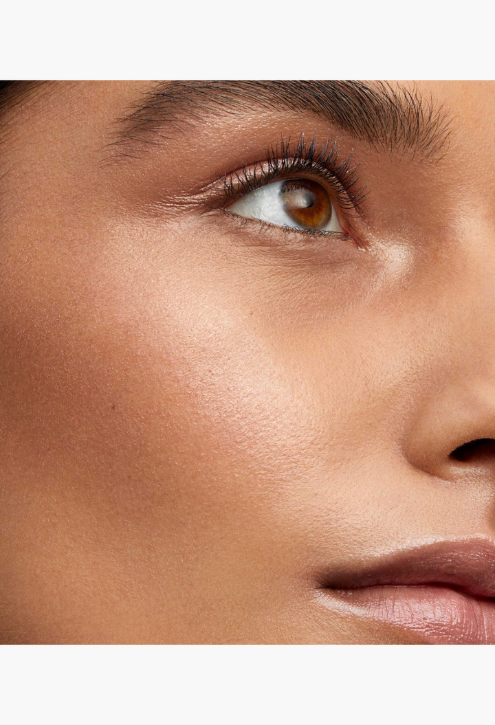 GLAM MODA Lit Up Highlight Stick applied to cheekbone for a radiant glassy finish on a model's face