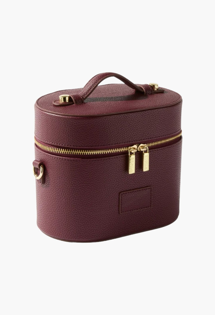 GLAM MODA burgundy vegan leather oval toiletry case with gold zippers and a top handle for travel organization.