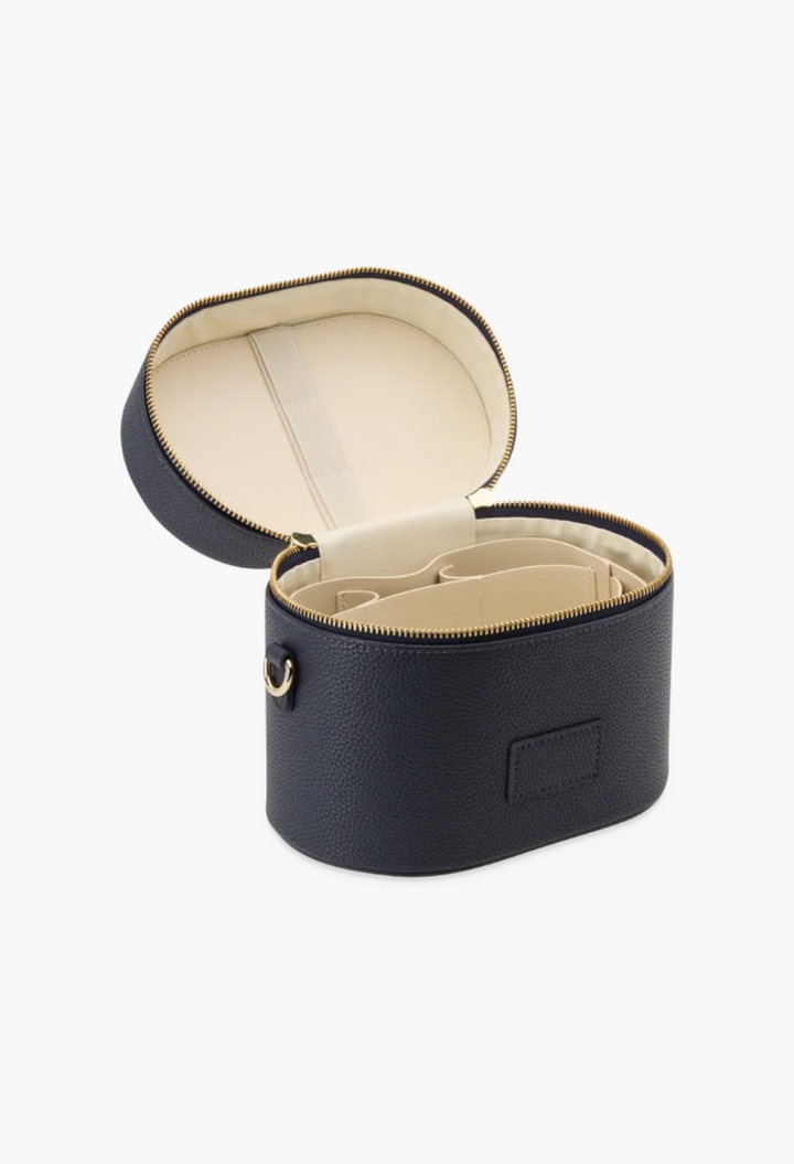 GLAM MODA navy blue oval vegan leather toiletry case with removable interior divider and cream-colored lining.