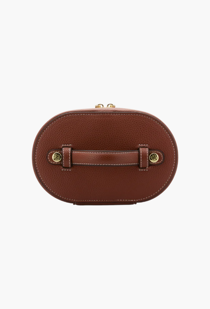 GLAM MODA oval toiletry case in brown vegan leather with a top carry handle and gold hardware details.