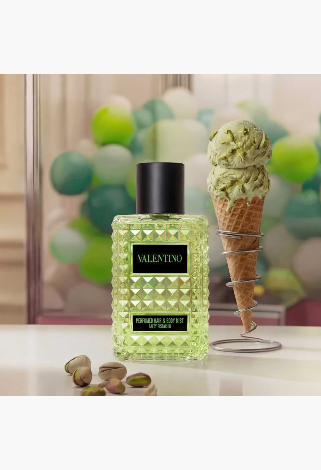GLAM MODA Valentino Born in Roma Salty Pistachio hair and body mist bottle next to a pistachio ice cream cone.