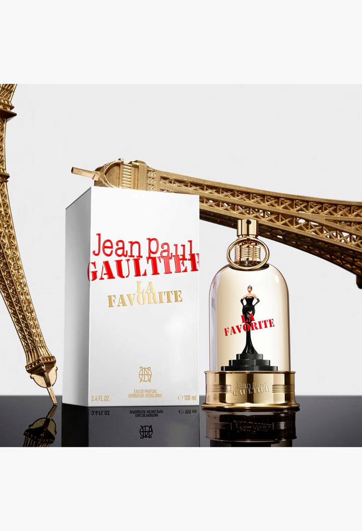 GLAM MODA Jean Paul Gaultier La Favorite perfume bottle on a pedestal with its box and a golden Eiffel Tower model.