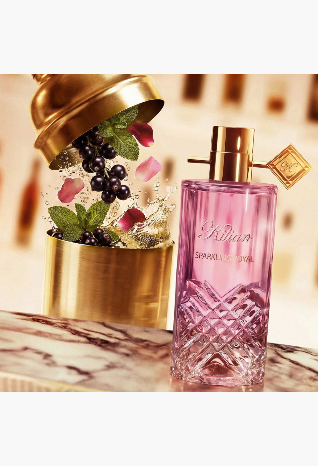 GLAM MODA Sparkling Royal Eau De Parfum bottle with pink glass and gold accents next to a cocktail shaker