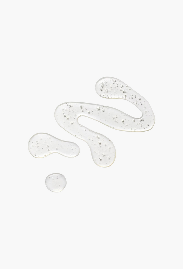 GLAM MODA Flourish Density Booster clear botanical scalp serum texture swatch on a white background