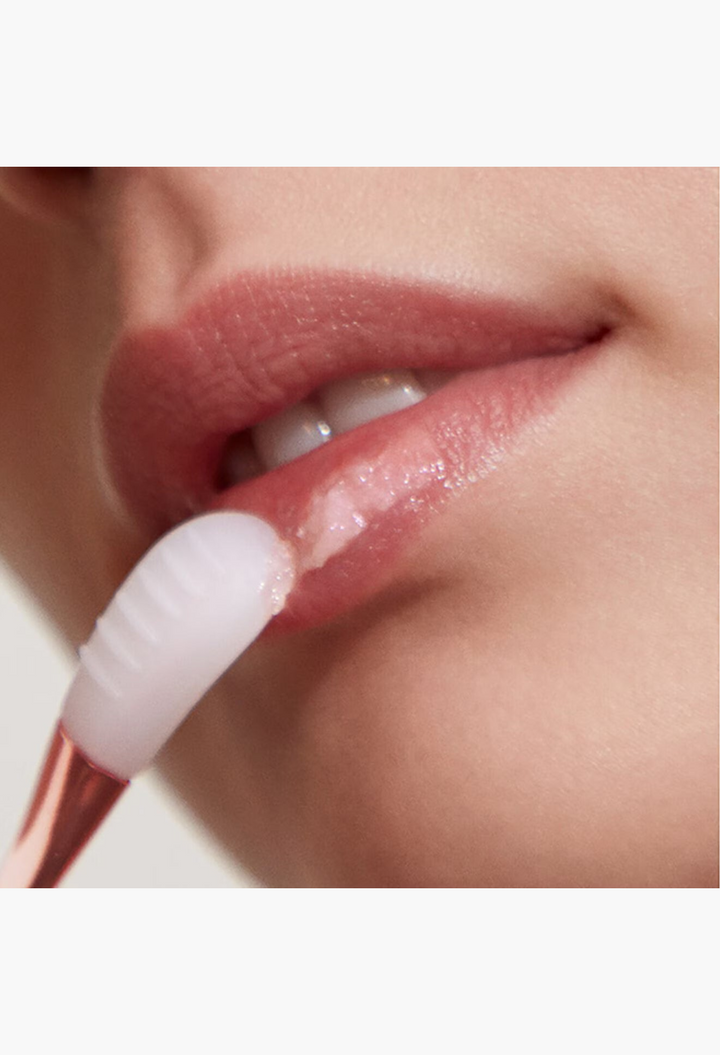 GLAM MODA The Lip Polish being applied with a dual-sided applicator to smooth and exfoliate lips for a soft finish.