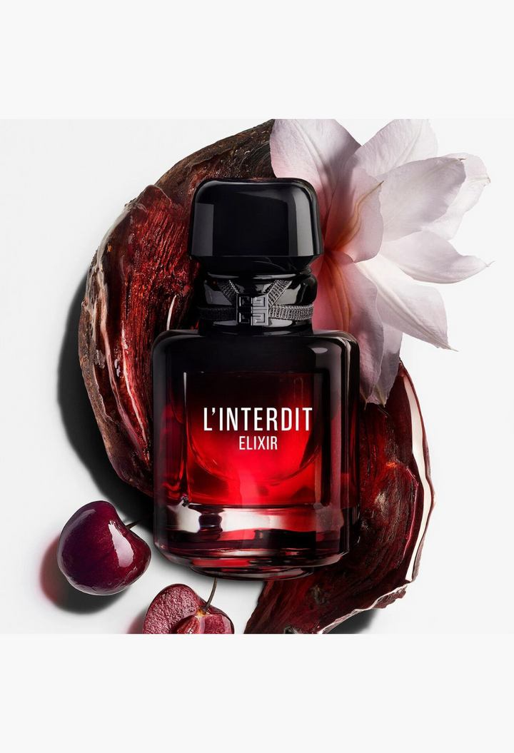 GLAM MODA L'Interdit Elixir perfume bottle with black cherry and white flower accents on a white background
