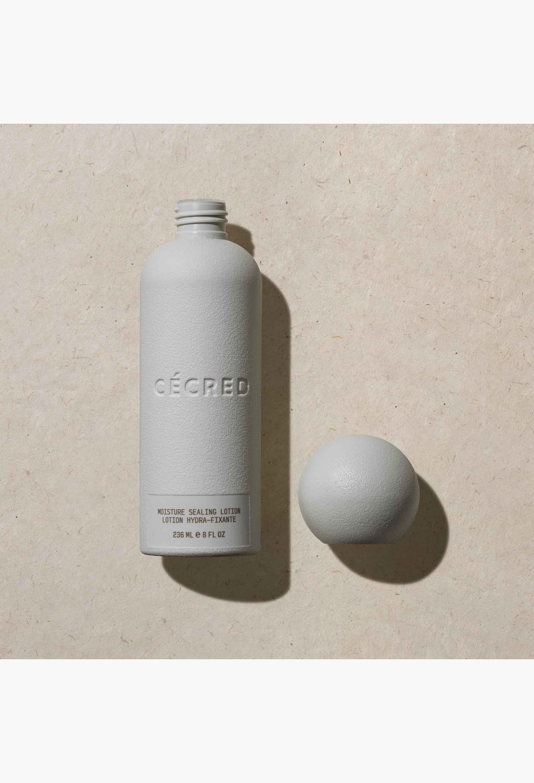 GLAM MODA Moisture Sealing Lotion in a textured grey bottle with a spherical cap for curl definition and hydration.