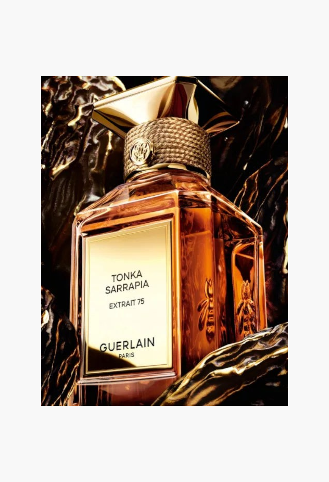 GLAM MODA Guerlain Tonka Sarrapia Extrait 75 perfume bottle with gold cap and bee emblem on dark textured background