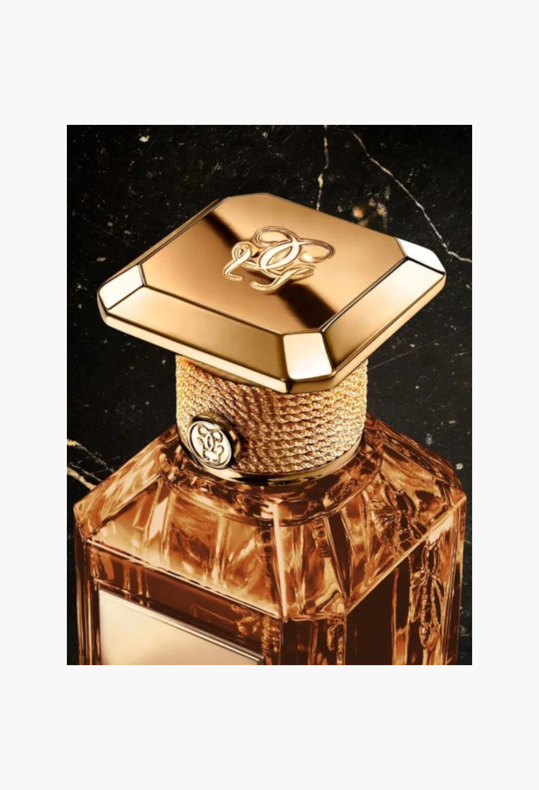 GLAM MODA Guerlain Tonka Sarrapia Extrait 75 perfume bottle with gold cap and textured neck on black marble surface