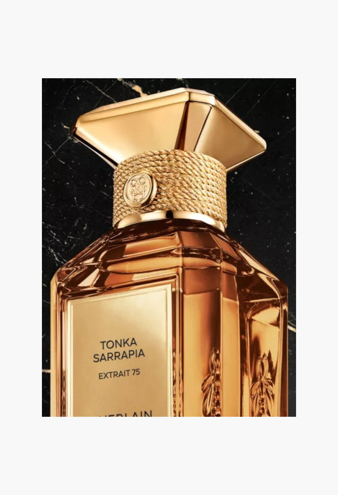 GLAM MODA Guerlain Tonka Sarrapia Extrait 75 perfume bottle with gold cap and rope detail on black marble background