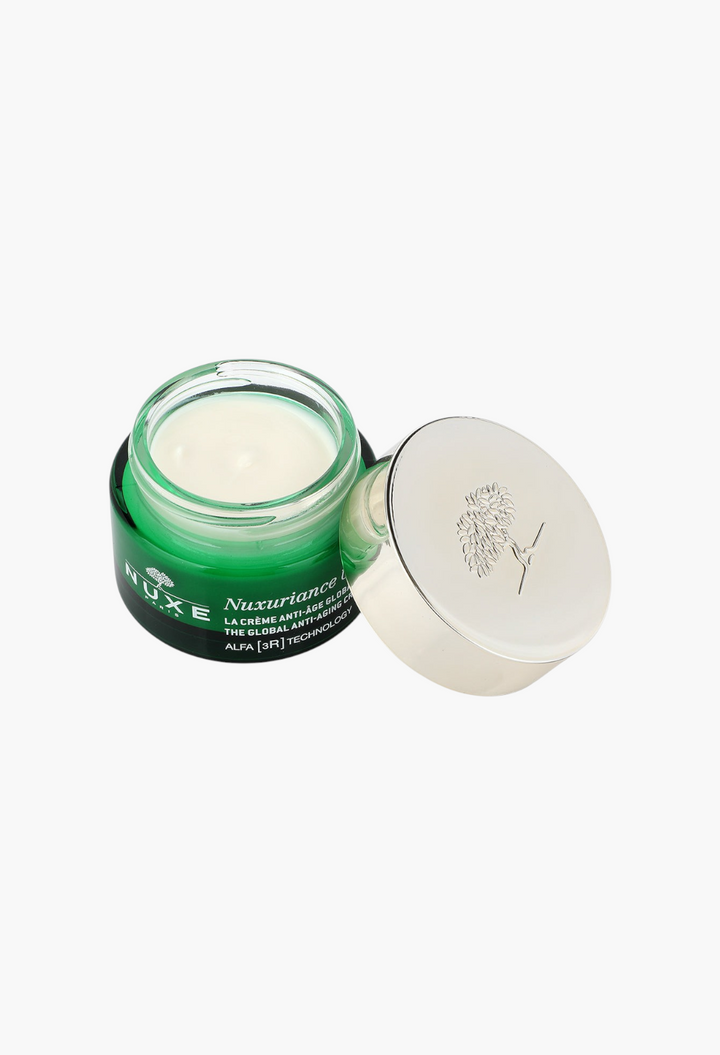GLAM MODA Nuxuriance Ultra anti-aging cream in a green glass jar with a silver lid and white rich face cream inside.
