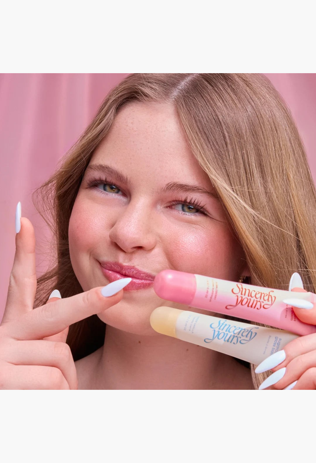 GLAM MODA The Sweet Tooth Set featuring two glossy lip balms in pink and clear shades held by a smiling young woman.