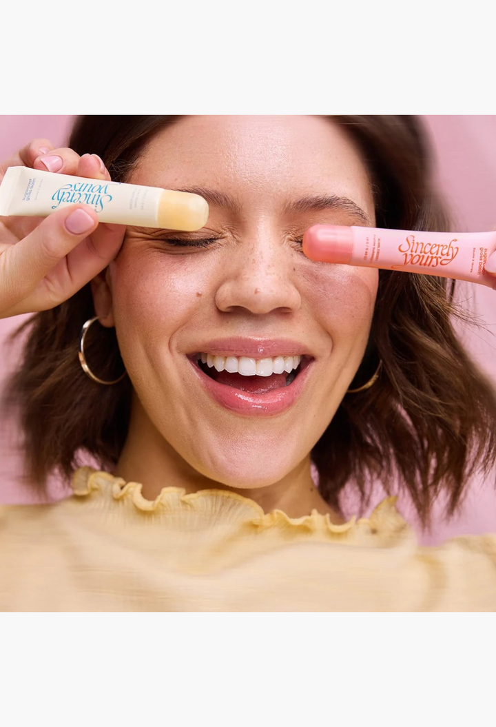 GLAM MODA The Sweet Tooth Set featuring two glossy lip balms in sheer vanilla and bubbleberry pink on a smiling model