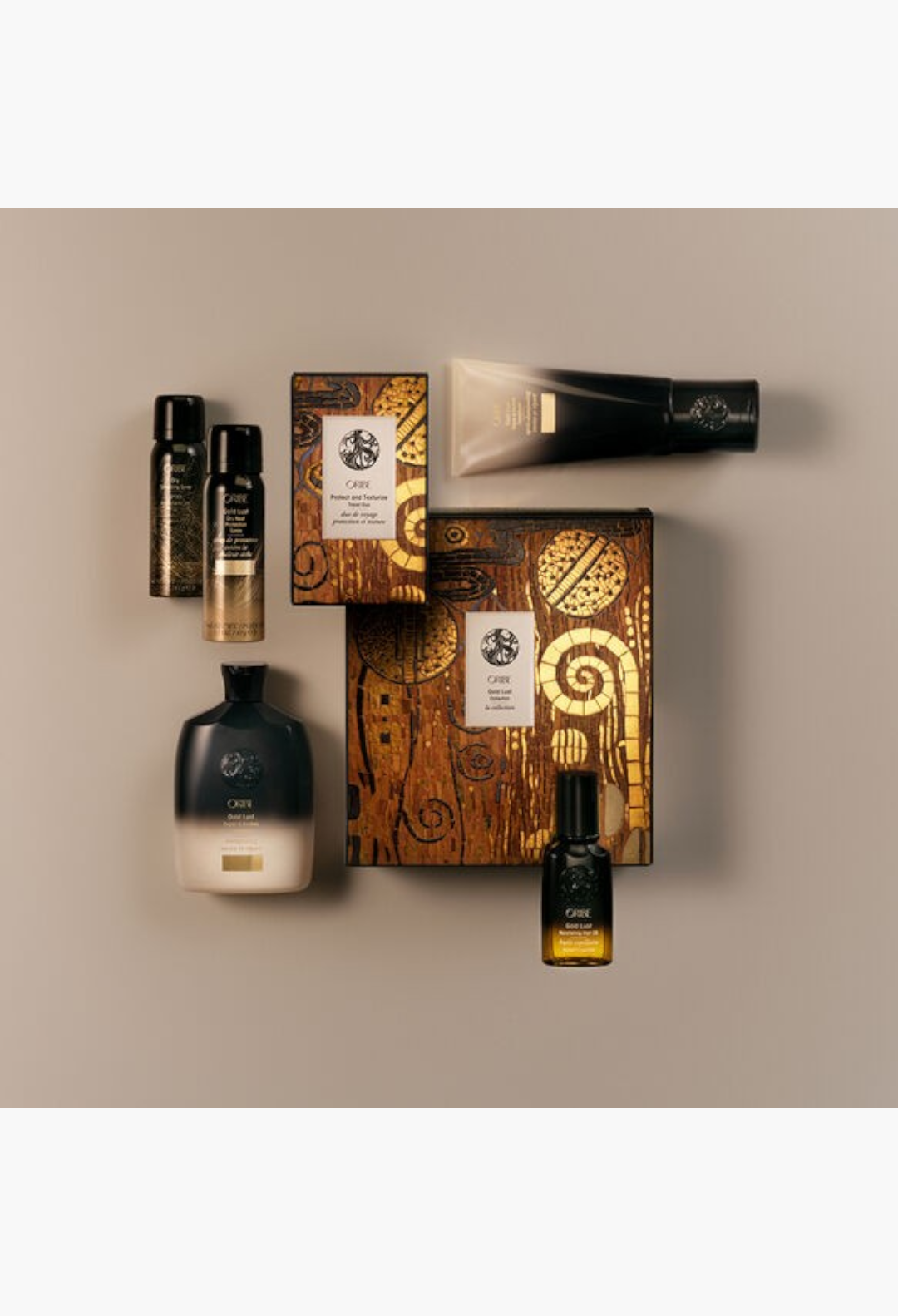 GLAM MODA Oribe Gold Lust haircare set featuring shampoo, conditioner, and nourishing oil in gold and black packaging.