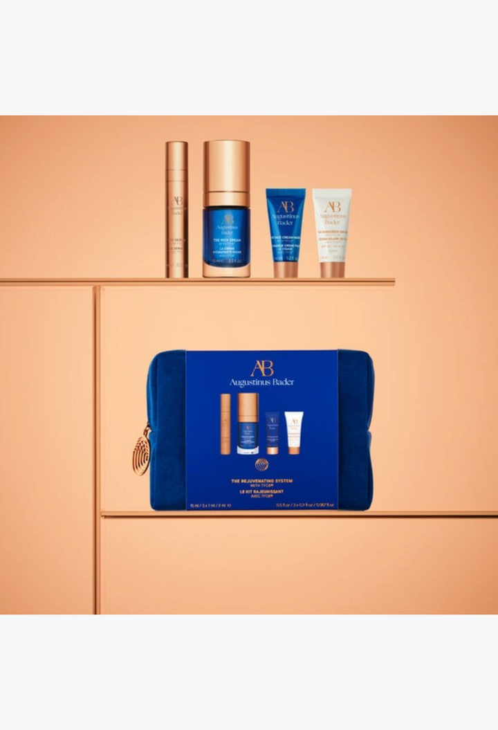 GLAM MODA Augustinus Bader The Rejuvenating System skincare set featuring four travel-sized creams and a blue pouch.