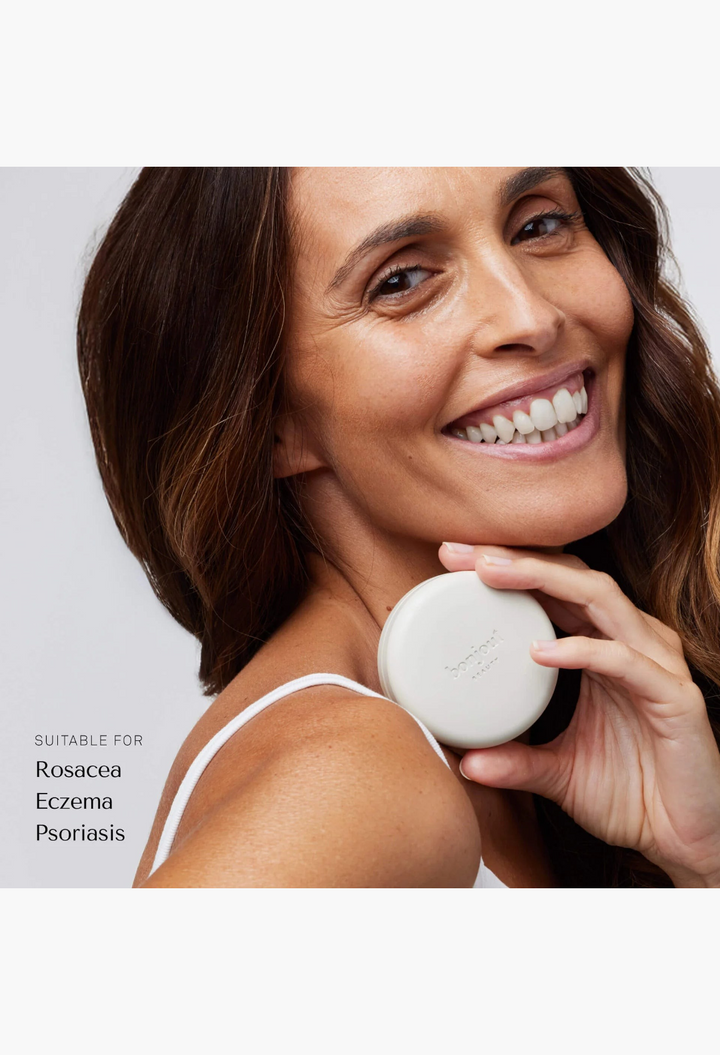 GLAM MODA Le Balm Trois unscented solid serum compact held by a smiling woman with radiant skin