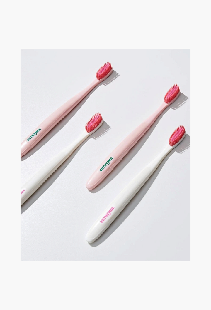 GLAM MODA Euthymol whitening toothbrushes with pink bristles and white or light pink handles on a white background