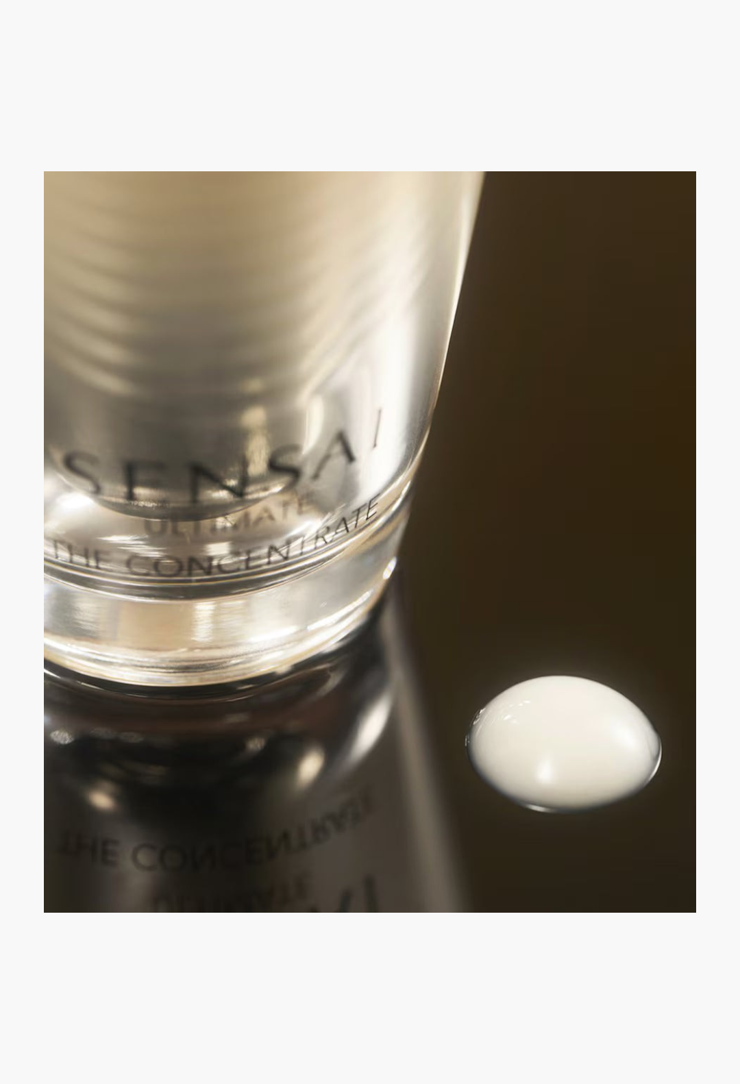 GLAM MODA Sensai Ultimate The Concentrate anti-ageing essence bottle with a drop of white nectar-like serum on surface