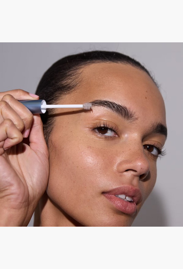 GLAM MODA model applying RapidBrow eyebrow enhancing serum with a spoolie brush for fuller and defined brows