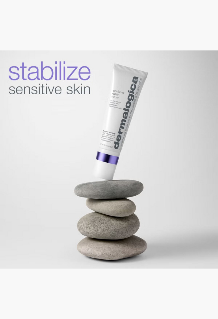 GLAM MODA Dermalogica Stabilizing Repair Serum tube balanced on a stack of smooth grey river stones