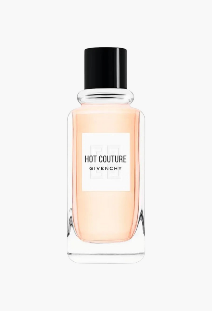 GLAM MODA Hot Couture Eau de Parfum in a clear glass bottle with a black cap and peach-toned fragrance liquid.
