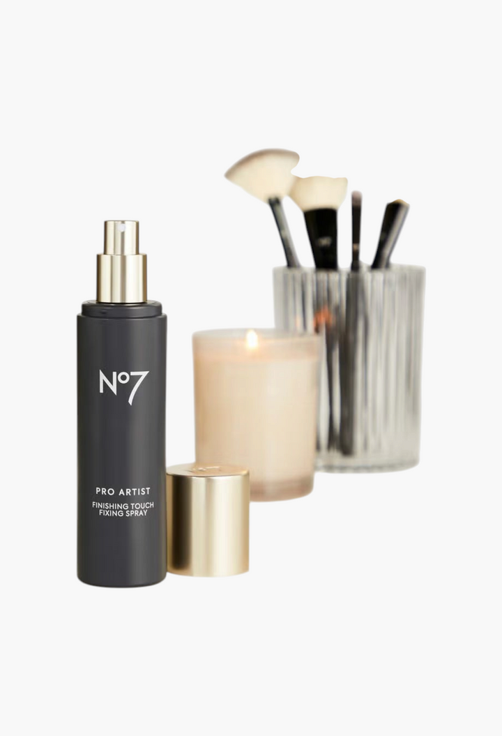 GLAM MODA No7 Pro Artist Finishing Touch fixing spray bottle with gold cap next to a candle and makeup brushes