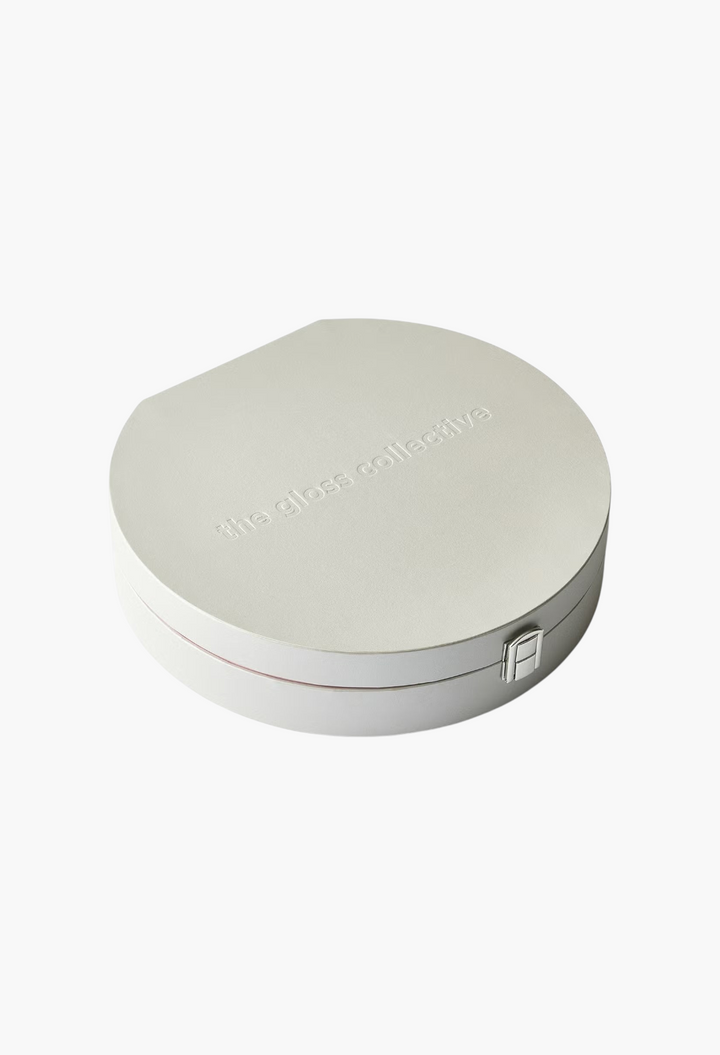 GLAM MODA The Gloss Collective limited-edition beauty gift set in a round, light grey textured presentation box.