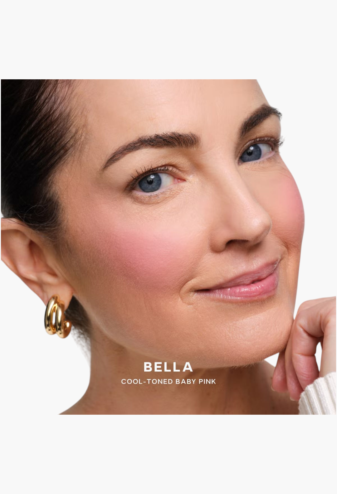 GLAM MODA Saie SuperSuede Radiant Blush in Bella, a cool-toned baby pink powder applied to a model's cheeks.